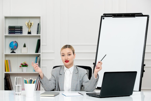 Teacher young cute instructor in suit in classrom with laptop and whiteboard holding pen