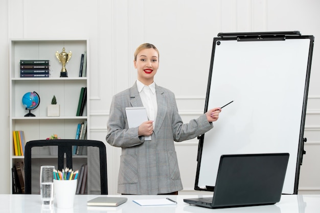 Teacher young cute instructor in suit in classrom with laptop and whiteboard standing by board