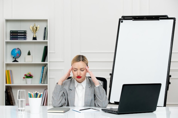 Free photo teacher young cute instructor in suit in classrom with laptop and whiteboard tired holding head