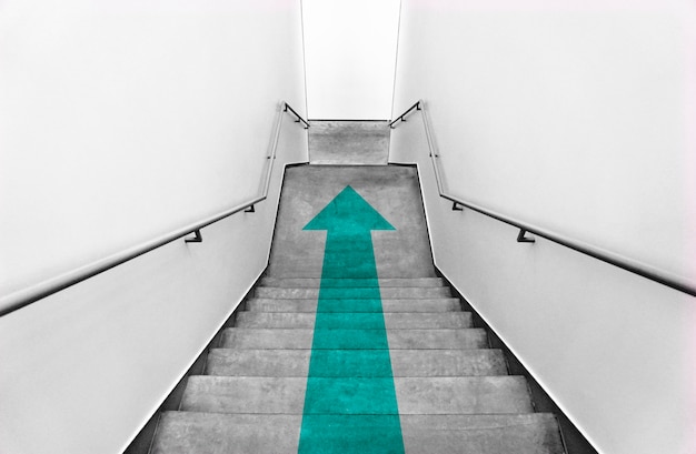 Free photo teal arrow on gray staircases