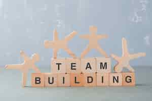 Free photo team building concept with wooden blocks, wooden human figures on it side view.
