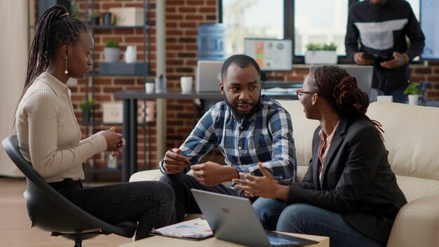 Team of business people collaborating to plan financial strategy, doing teamwork to create sales report on laptop. Office employees working on project strategy to analyze career growth.