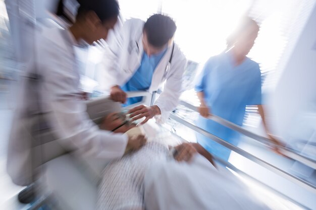 Team of doctors putting oxygen mask on a male senior patient face