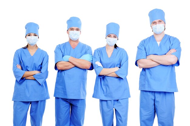 Team of four surgeons in blue uniform standing together