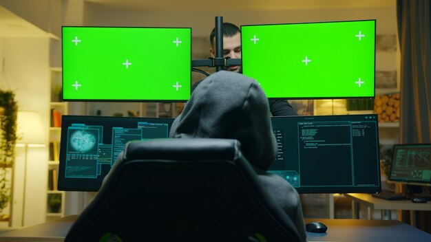 政府から秘密情報を盗むためにグリーンスクリーンモックアップを備えたコンピューターを使用しているハッカーのチーム。