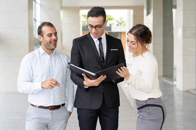 Team of happy financiers reading report on company progress