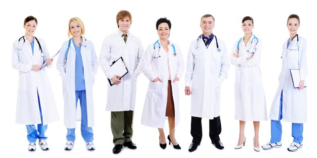 Team of happy laughing doctors standing in line on white