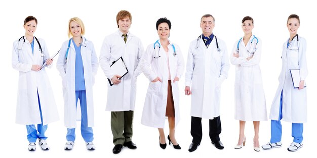 白の上に並んで立っている幸せな笑い医師のチーム