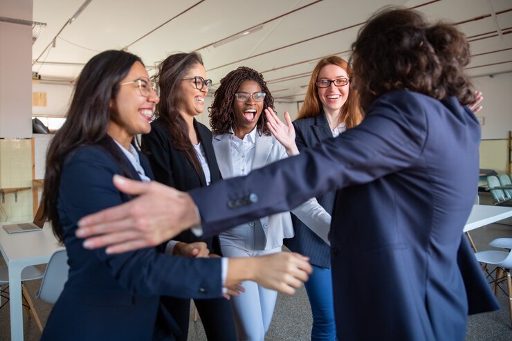Free Photo team leader hugging her happy younger colleagues