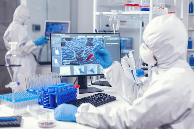 Free photo team of medical engineers test blood to find a cure for coronavirus in science laboratory. doctor working with various bacteria and tissue, pharmaceutical research for antibiotics against covid19.