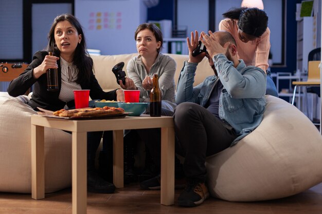 Team of multi ethnic friends losing tv game on console