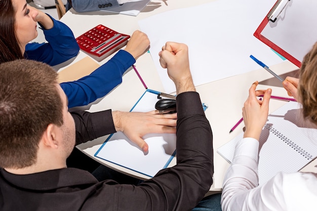 Foto gratuita team seduto dietro la scrivania, controllando i rapporti, parlando. il concetto di business di collaborazione, lavoro di squadra, riunione