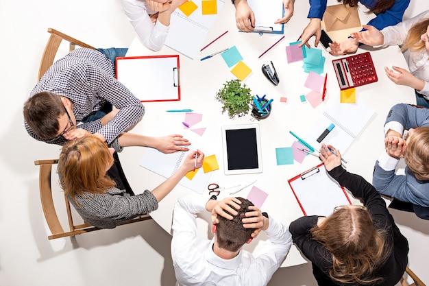 Team seduto dietro la scrivania, controllando i rapporti, parlando. vista dall'alto. concetto di business di collaborazione, lavoro di squadra, riunione