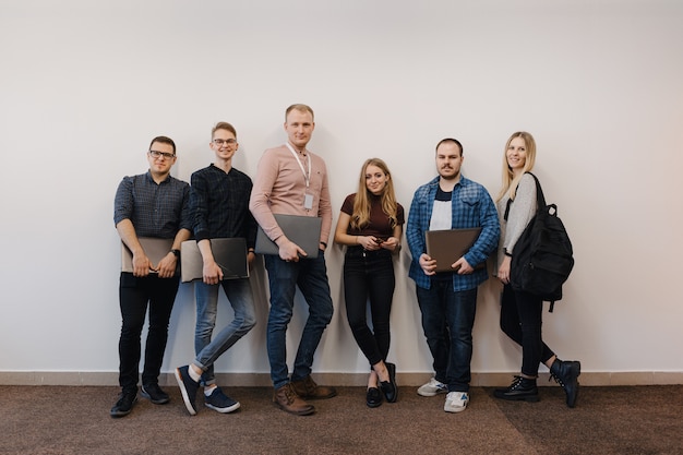 Team of six office workers on white wall