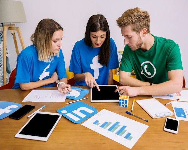 Team of social media networking looking at digital tablet in the office