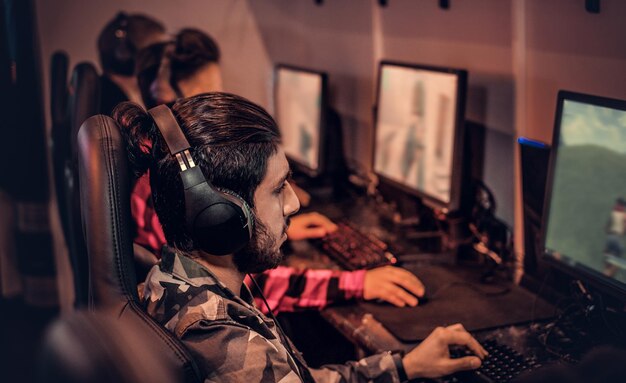 A team of teenage gamers plays in a multiplayer video game on pc in a gaming club.