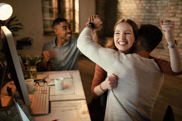 Team of young entrepreneurs celebrating business success in the office Focus is on woman