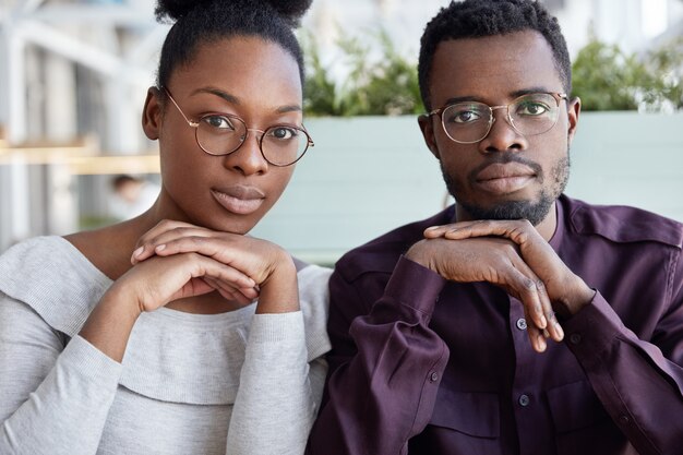 팀워크와 협력 개념. 성공적인 아프리카 계 미국인 여성 및 남성 동료는 서로 가까이 앉아 안경을 착용합니다.