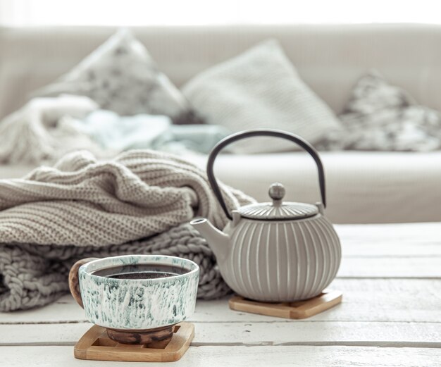 A teapot and a beautiful ceramic cup in a hygge style living room