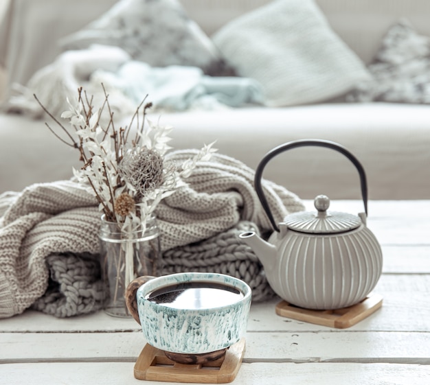 A teapot and a beautiful ceramic cup with decor details in a hygge style living room