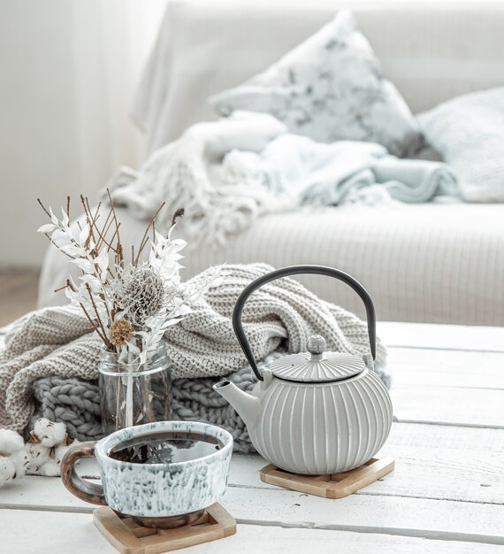 hygge 스타일의 거실에 장식 된 세부 사항이있는 주전자와 아름다운 세라믹 컵