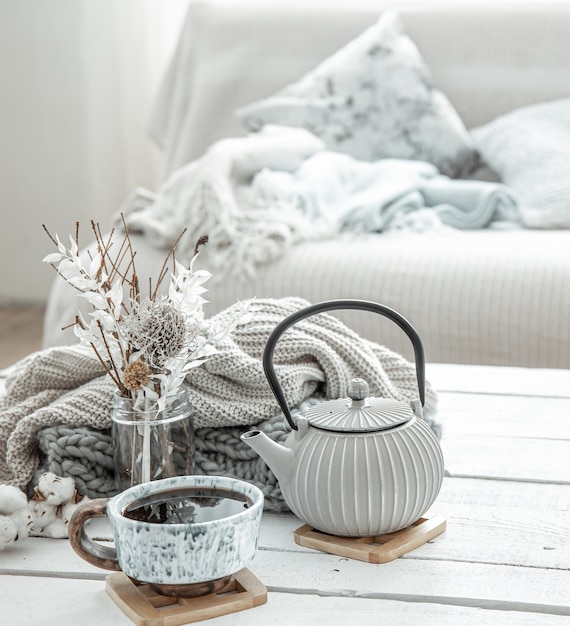 A teapot and a beautiful ceramic cup with decor details in a hygge style living room