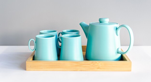 Teapot and cups a set of dishes for tea drinking in a wooden tray