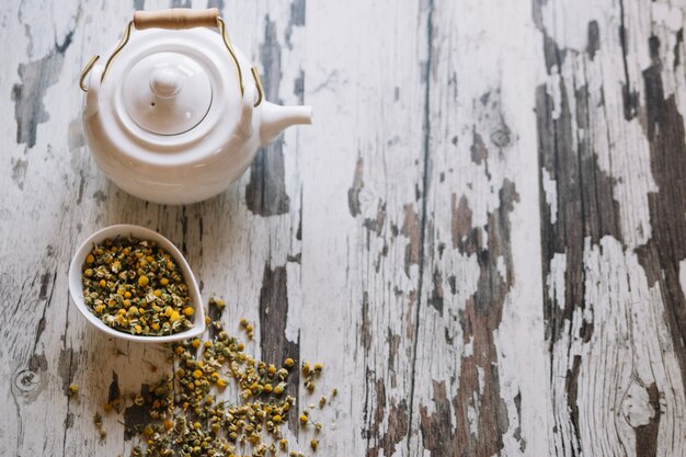 Free photo teapot and dried chamomiles