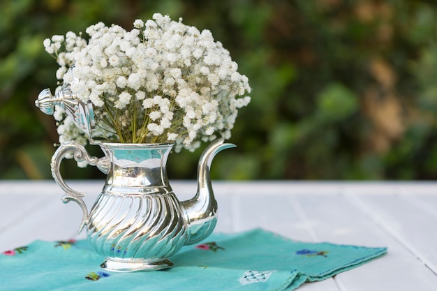 Free photo teapot with white flowers