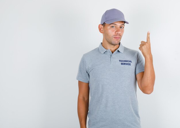 Technical service man showing finger up in grey t-shirt with cap