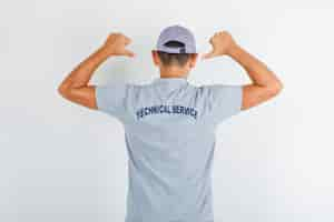 Free photo technical service man showing text on uniform in grey t-shirt with cap