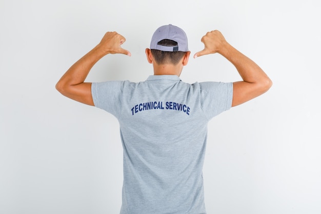 Technical service man showing text on uniform in grey t-shirt with cap