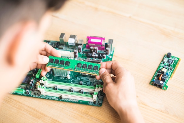 Technician testing RAM of computer motherboard on table