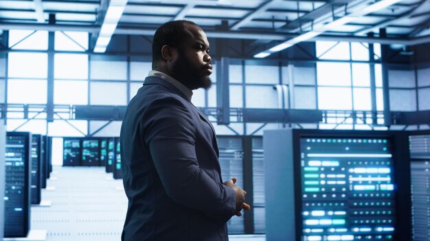 technician walking in data center monitoring systems to identify errors