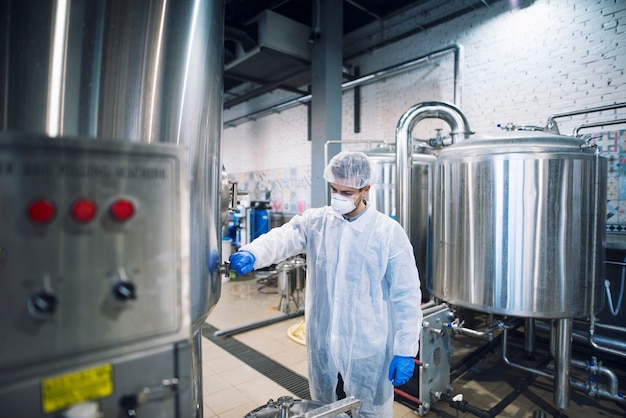 Technologist controlling machine in production plant