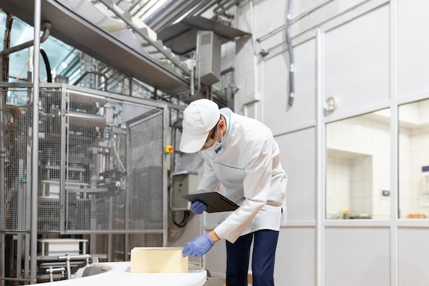 Free photo technologist make set up of the production line while standing near digital screen at the department of dairy factory