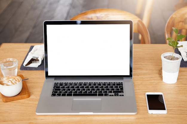 Technology, business and communication concept. Front view of minimalist workspace of freelancer: modern laptop computer