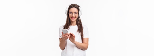 Free photo technology lifestyle and music concept portrait of charismatic smiling young woman in headphones lis