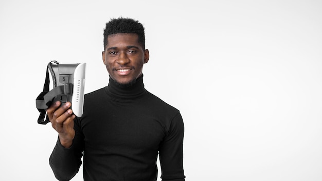 Technology man holding a virtual reality headset front view