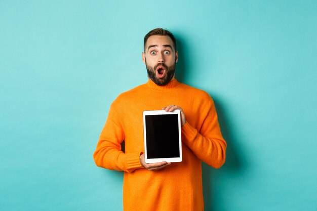 Technology. Surprised bearded man drop jaw, showing digital tablet screen