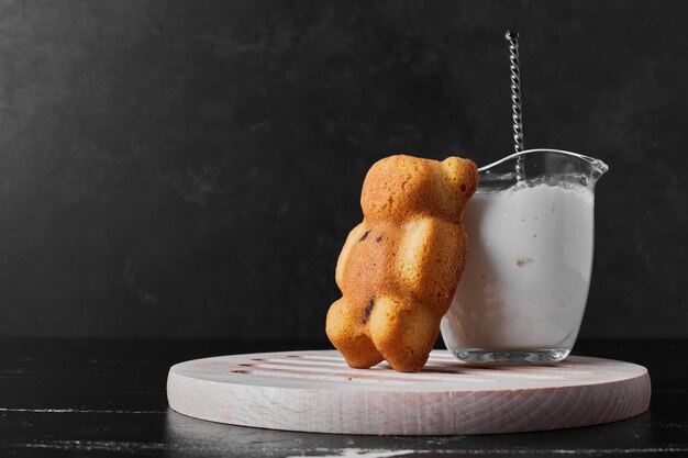 Teddy bear biscuit with a cup of milk.