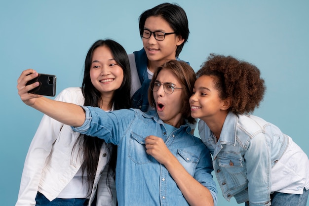 Free photo teen best friends posing together while doing a selfie