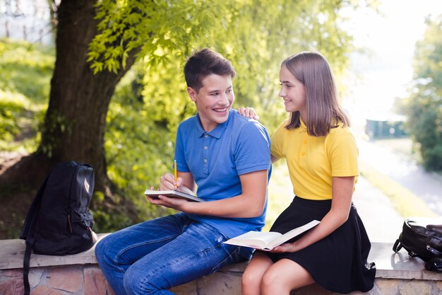 Teen boy doing homework with girlfriend