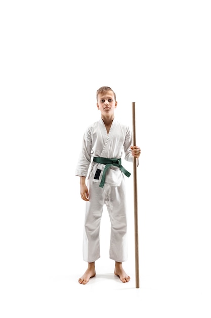 Teen boy fighting with wooden sword at Aikido training in martial arts school