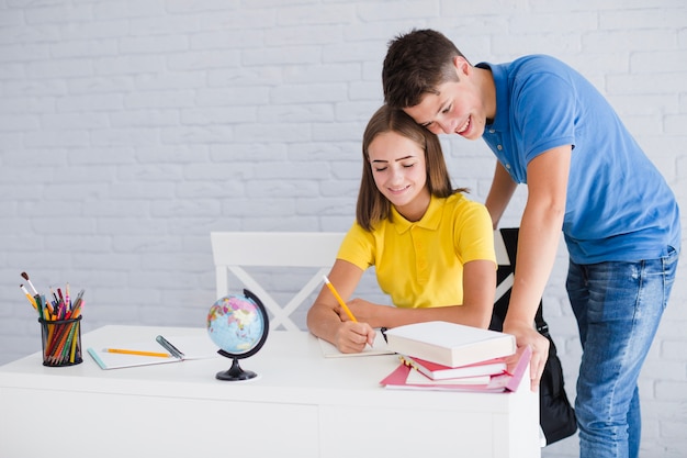 Teen boy helping his girlfriend to study