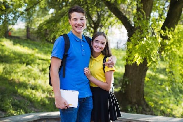 Free photo teen boy hugging girl in park