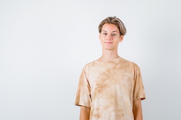 Foto gratuita ragazzo adolescente in posa mentre guarda davanti in t-shirt e sembra soddisfatto. vista frontale.