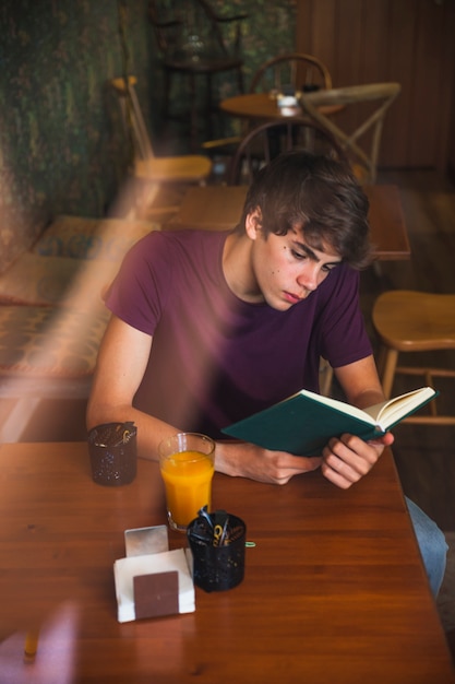 Teen boy reading boy in nice cafe