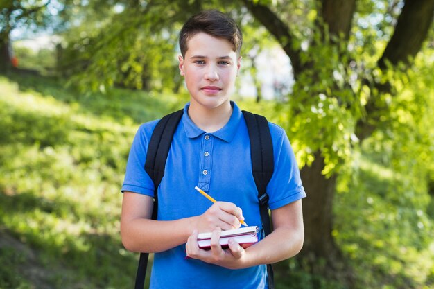 Teen boy writing in notebook