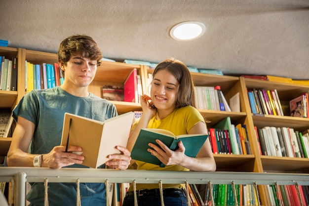 Foto gratuita coppia teen studiando in biblioteca